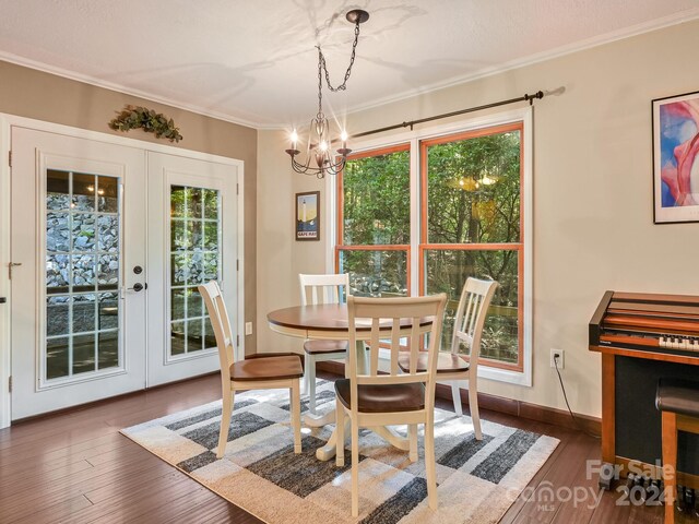 dining space featuring crown molding, french doors, dark hardwood / wood-style flooring, and an inviting chandelier