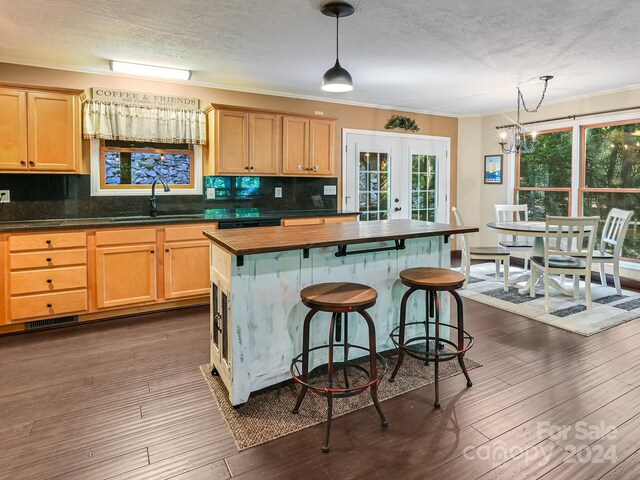 kitchen with pendant lighting, a kitchen bar, plenty of natural light, and sink