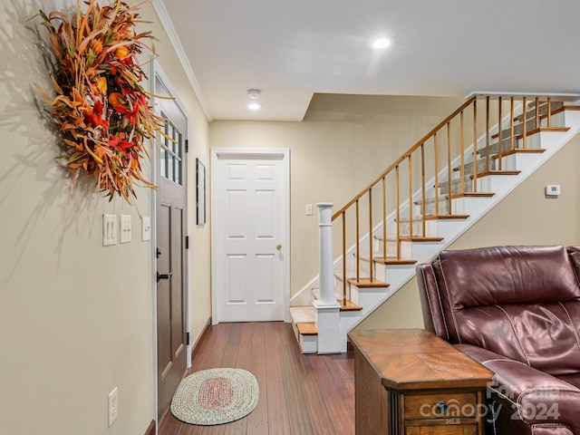 foyer with crown molding and dark wood-type flooring