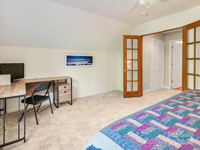 bedroom with lofted ceiling, a closet, ceiling fan, and light carpet