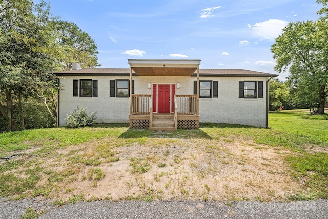 ranch-style house with a front yard and brick siding