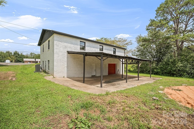 back of house featuring a patio area, a yard, central AC, and brick siding