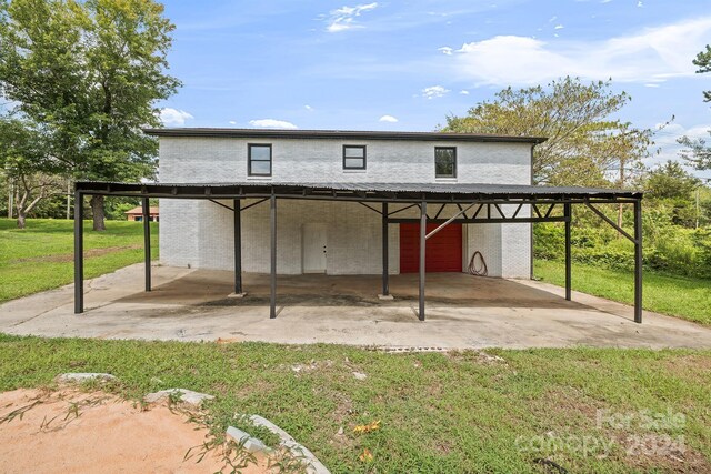 back of house featuring a lawn and a carport