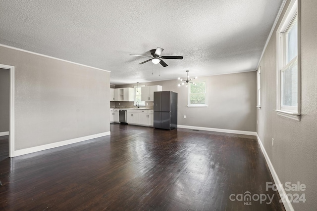 unfurnished living room featuring baseboards, dark wood-type flooring, a textured ceiling, a sink, and ceiling fan with notable chandelier