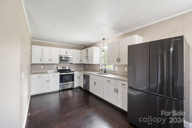 kitchen featuring white cabinetry, appliances with stainless steel finishes, dark wood finished floors, and a sink