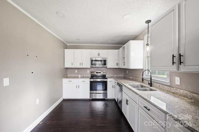 kitchen with dark wood-type flooring, white cabinets, light stone countertops, sink, and stainless steel appliances