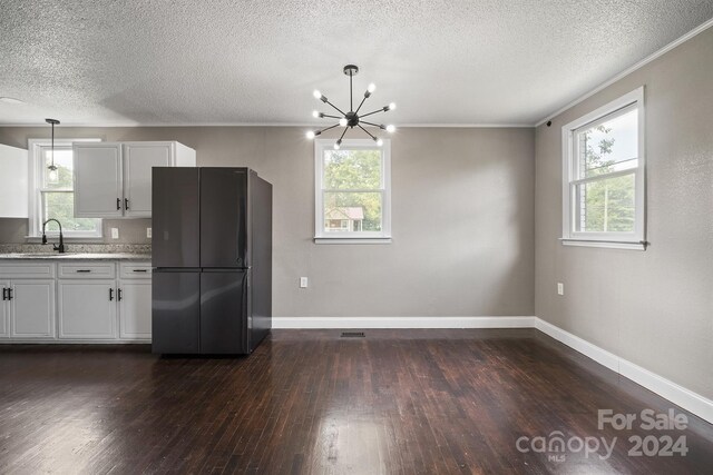 kitchen featuring black refrigerator, plenty of natural light, and dark hardwood / wood-style floors