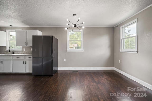 kitchen with dark wood-type flooring, freestanding refrigerator, a healthy amount of sunlight, and a sink