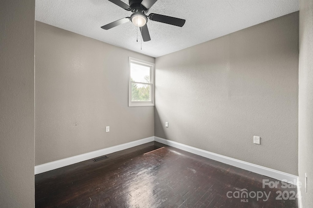 spare room with visible vents, baseboards, dark wood finished floors, ceiling fan, and a textured ceiling