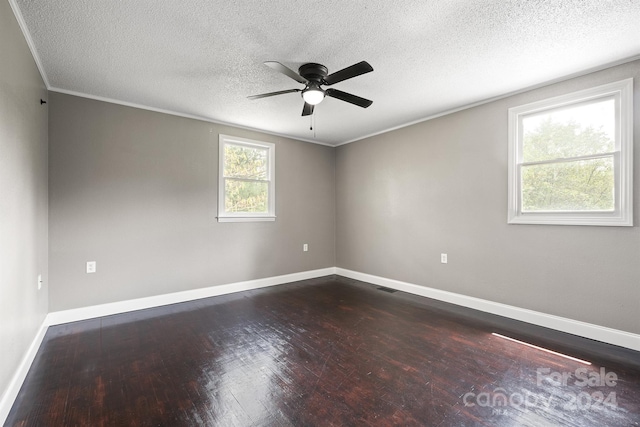 empty room with ceiling fan, a textured ceiling, baseboards, dark wood finished floors, and crown molding