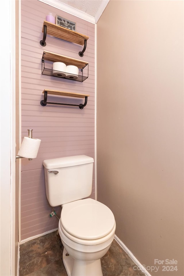 bathroom featuring toilet and crown molding