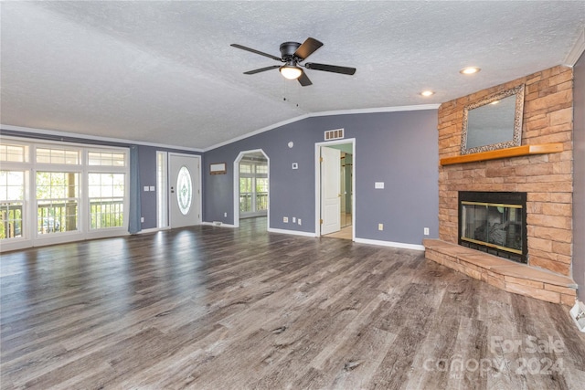 unfurnished living room featuring a fireplace, ornamental molding, ceiling fan, dark hardwood / wood-style floors, and lofted ceiling