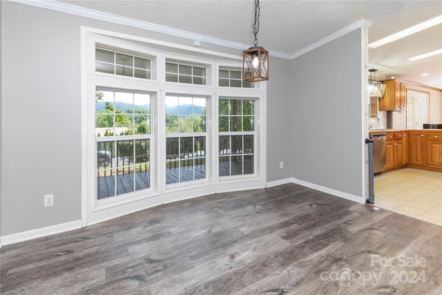 unfurnished dining area with sink, wood-type flooring, an inviting chandelier, and ornamental molding