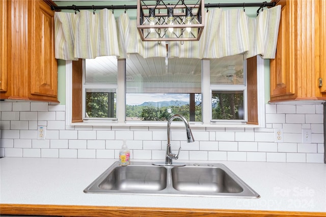 kitchen with a wealth of natural light, tasteful backsplash, and sink