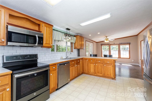 kitchen featuring pendant lighting, crown molding, stainless steel appliances, sink, and kitchen peninsula