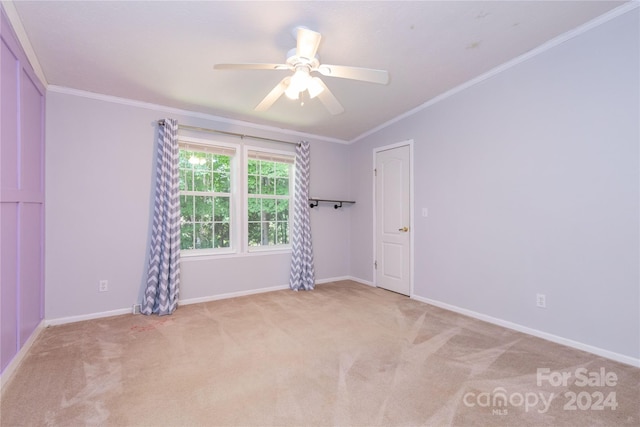 carpeted empty room featuring crown molding and ceiling fan