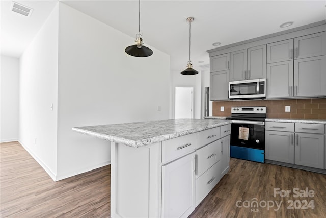 kitchen with gray cabinetry, a kitchen island, dark hardwood / wood-style flooring, hanging light fixtures, and stainless steel appliances