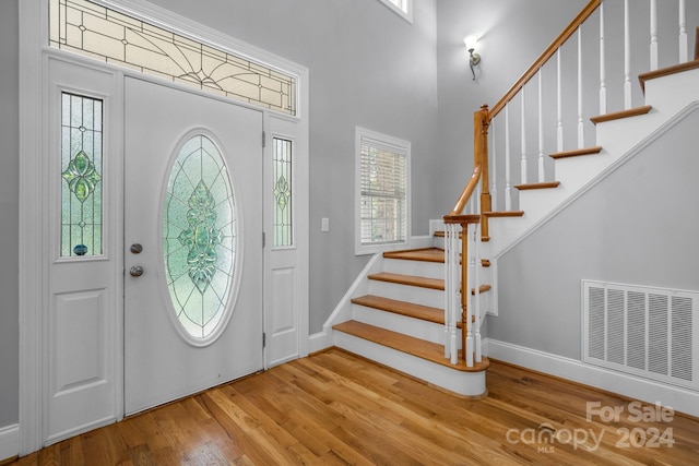 entrance foyer with plenty of natural light, a high ceiling, and hardwood / wood-style flooring