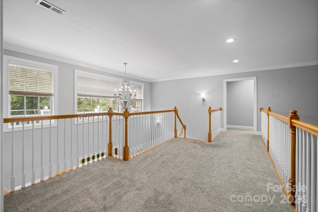 empty room with carpet flooring, a notable chandelier, and crown molding