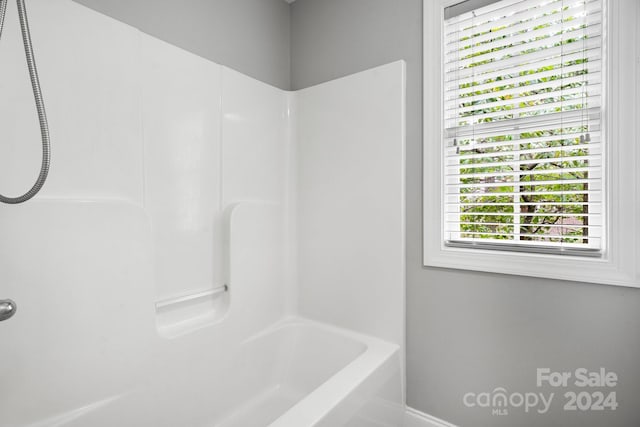 bathroom featuring washtub / shower combination and a healthy amount of sunlight