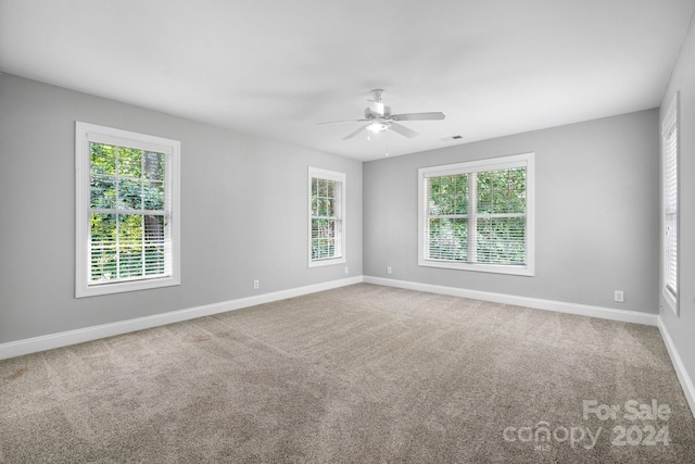 spare room featuring carpet flooring, ceiling fan, and a healthy amount of sunlight