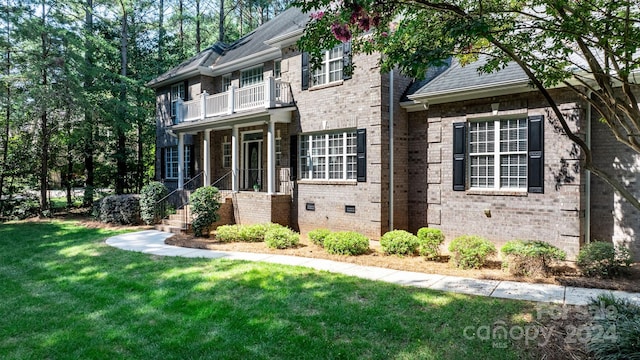 view of front of home featuring a balcony and a front lawn