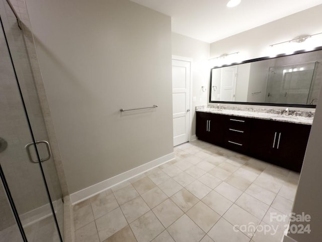 bathroom with tile patterned flooring, vanity, and walk in shower