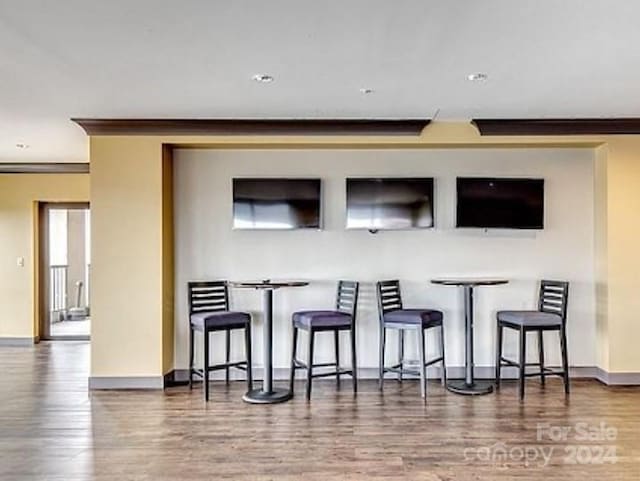 bar featuring crown molding and hardwood / wood-style flooring