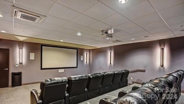 carpeted home theater room with a paneled ceiling