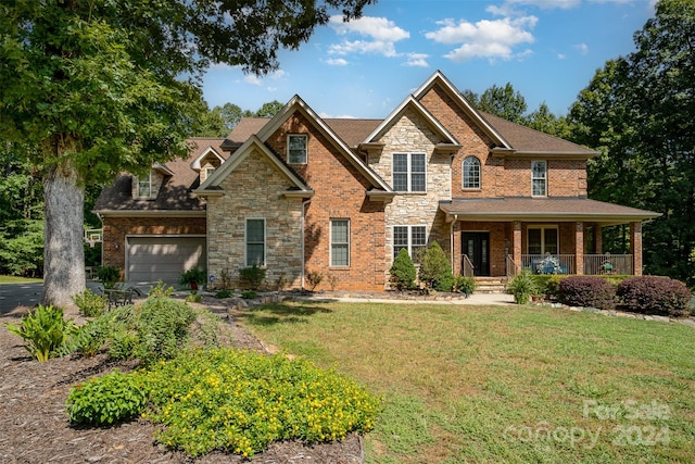 craftsman-style home with a front yard, a garage, and covered porch