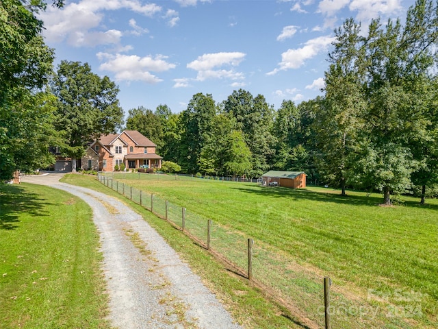 view of street with driveway and a rural view