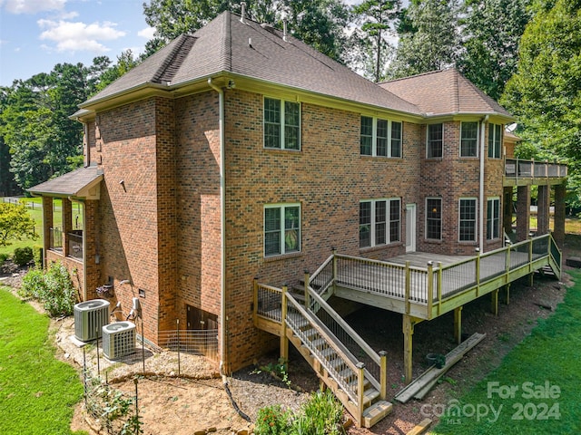 rear view of house with central AC unit and a wooden deck