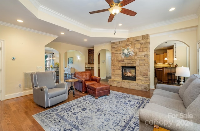 living room featuring ceiling fan, hardwood / wood-style floors, and crown molding