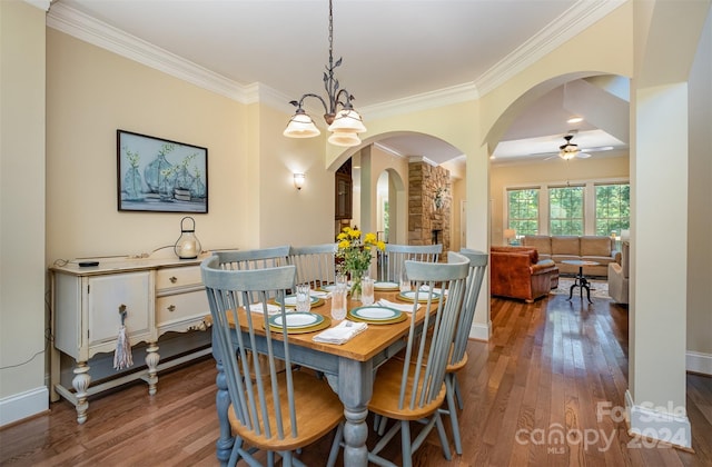 dining space with crown molding, ceiling fan with notable chandelier, and wood-type flooring