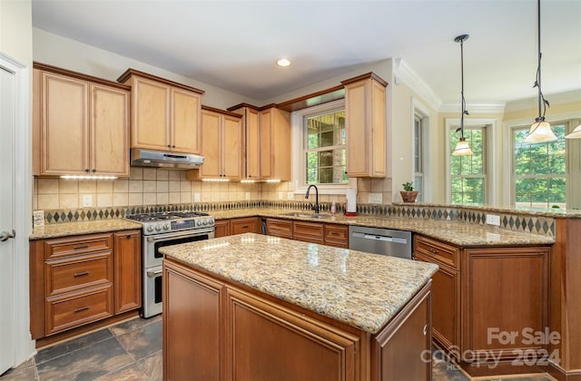 kitchen featuring appliances with stainless steel finishes, dark tile patterned floors, tasteful backsplash, pendant lighting, and a kitchen island