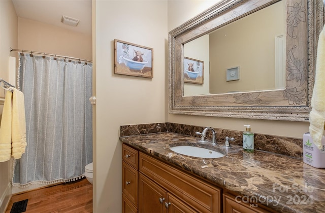 bathroom featuring a shower with curtain, vanity, hardwood / wood-style floors, and toilet