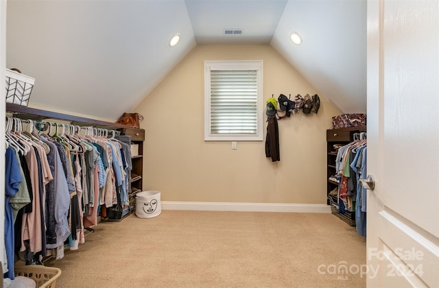 walk in closet with carpet floors, visible vents, and vaulted ceiling