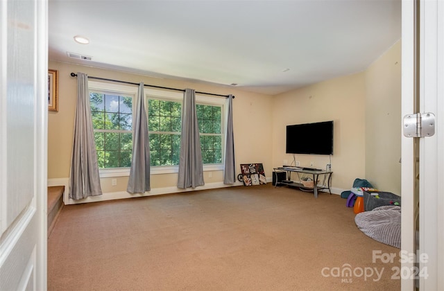 living room featuring carpet, visible vents, and baseboards