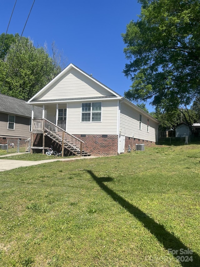 view of front of house featuring central air condition unit and a front yard