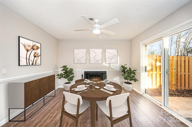 dining space with wood-type flooring, ceiling fan, and a textured ceiling