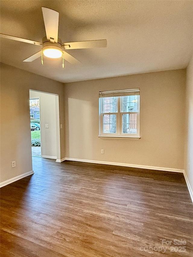 empty room with a textured ceiling, dark hardwood / wood-style floors, and ceiling fan