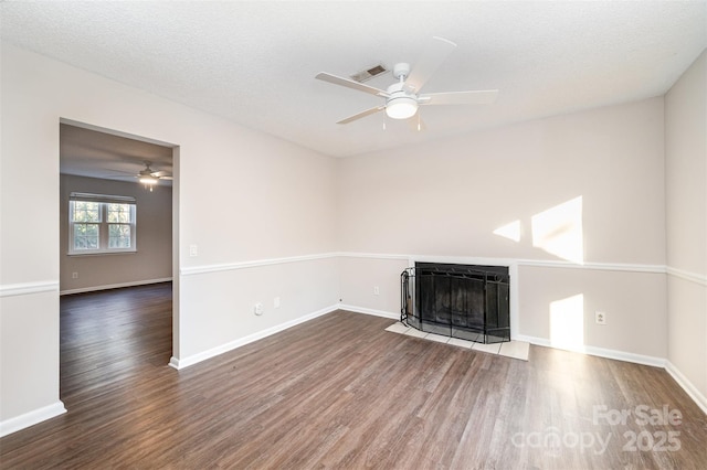 unfurnished living room featuring ceiling fan, dark hardwood / wood-style floors, and a textured ceiling