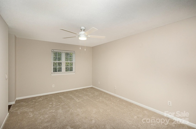 spare room with light carpet, ceiling fan, and a textured ceiling