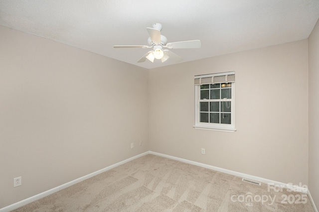 carpeted spare room with ceiling fan