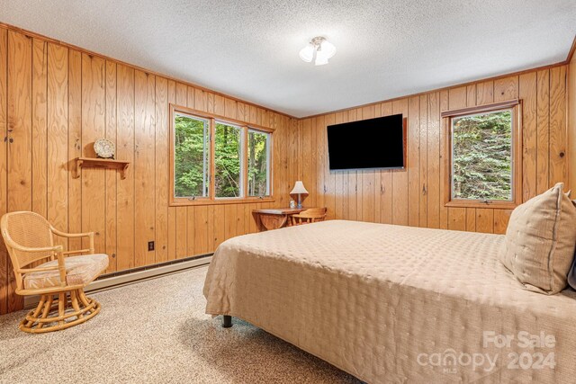 bedroom featuring carpet, wood walls, and multiple windows