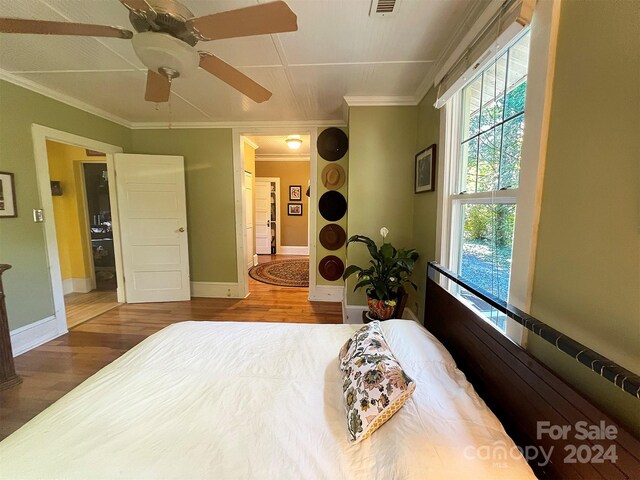 bedroom featuring ceiling fan, ornamental molding, and hardwood / wood-style flooring