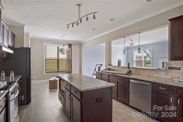 kitchen featuring decorative light fixtures, appliances with stainless steel finishes, a kitchen island, and dark brown cabinetry