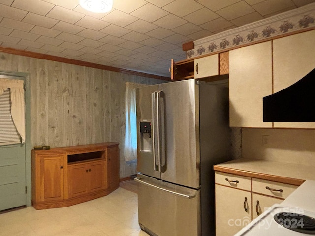 kitchen with stainless steel fridge with ice dispenser, light tile patterned floors, and crown molding