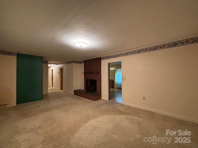 unfurnished living room with light carpet, a fireplace, a textured ceiling, and baseboards