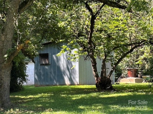 view of home's exterior with a lawn and an outdoor structure